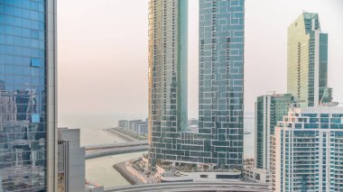 Gezinti güvertesi ve Dubai şehir manzarası Dubai marinasından görüldü. JBR bölgesi ve Bluewater Adası 'nın arkasında oteller ve gökdelenler var..