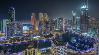 Dubai Marina 'da limanda park etmiş tekneleri ve yatları var ve tüm gece boyunca kanalın çevresindeki gökdelenleri aydınlatıyorlar. Arka planda JBR bölgesi kuleleri