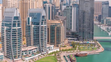 Dubai Marina 'da limana park etmiş birkaç tekne ve yatları ve kanalın etrafında gökdelenleri var. JBR ilçesinin kulelerine yakın görüş