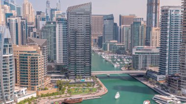 Dubai Marina 'da limana park etmiş birkaç tekne ve yatları ve kanalın etrafında gökdelenleri var. Su üzerinde kuleler ve köprüler