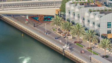 Dubai Marina Rıhtımı ve şehir gezinti alanı hava zaman çizelgesi. Kanal boyunca gökdelenler ve restoranlar.