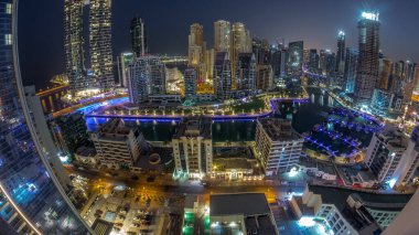 Dubai Marina Panoraması 'nda limana park edilmiş tekne ve yatlar ve gün doğumundan önce gece gündüz kanal havası çevresindeki gökdelenleri aydınlatıyordu. Arka planda JBR bölgesi kuleleri