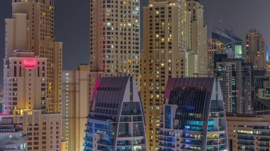 Dubai Marina 'daki modern gökdelenler, birçok aydınlık pencereye yakın gece zaman aralığı. Yukarıdan JBR bölgesindeki modern kuleler