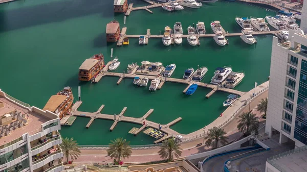 Birçok yat ve tekne liman havası zaman dilimine park edilmiştir. Dubai Marina rıhtımı yürüyüş alanı. Modern tekne derede yüzüyor..
