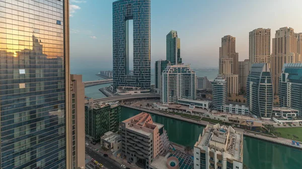 在日出期间 迪拜的滨海摩天大楼和Jbr区 阳光反射在豪华的建筑物和度假胜地的空中时间 有手掌和小船漂浮在运河中 — 图库照片