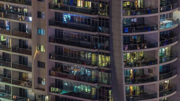 外観のアパートカラフルな建物のタイムラプスの夜景 窓が輝く高層ビル ガラス面から反射する光 — ストック写真