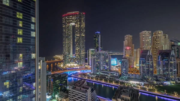 迪拜滨海摩天大楼和Jbr区的豪华建筑和度假胜地的空中时间通宵与灯关闭 发光的海滨和漂浮在运河中的船只 — 图库照片