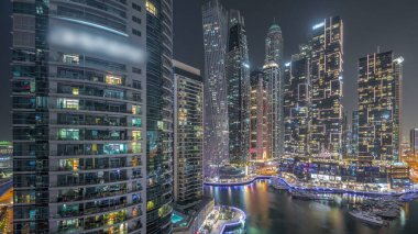 Dubai marinası en uzun gökdelenler parlayan pencereleri ve yatları olan liman havası gece saatlerinde. Apartman binalarına, otellere ve ofis bloklarına, BAE 'nin modern yerleşim alanlarına bak