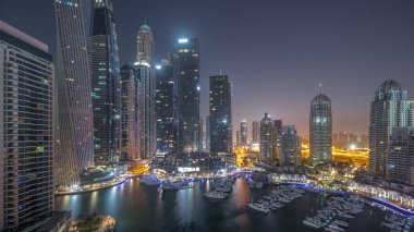 Dubai marinası en uzun gökdelenler ve yatlar liman havasında gece gündüz geçiş zamanları gün doğumunda. Apartman binalarına, otellere ve ofis bloklarına, BAE 'nin modern yerleşim alanlarına bak