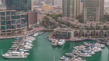 Dubai Marina hava sahasına yanaşmış lüks tekne ve yatlar. Limandaki rıhtım boyunca parkedilmiş sürat tekneleri. Yolda trafik vardı.