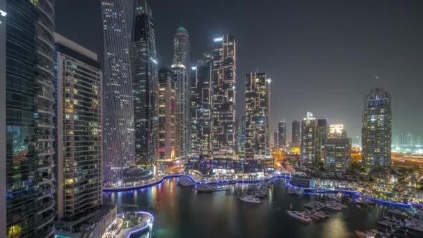 Dubai jachthaven hoogste wolkenkrabbers en jachten in de haven lucht nacht timelapse. — Stockvideo