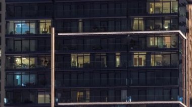 Çok katlı binaların pencerelerinde düz gece panoramasında çok renkli ışık var..