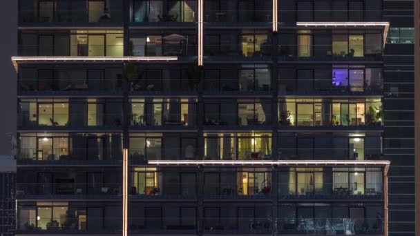 Panorama nocturne plat de lumière multicolore dans les fenêtres de bâtiments à étages multiples timelapse aérienne. — Video