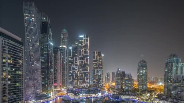 Dubai marina tallest skyscrapers and yachts in harbor aerial all night timelapse. — Stock Video