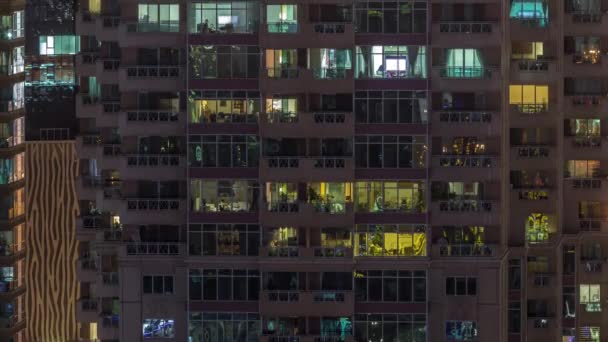 Panorama nocturno plano de luz multicolor en ventanas de edificios de varios pisos timelapse aéreo. — Vídeo de stock