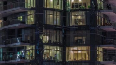 Çok katlı binaların pencerelerinde düz gece panoramasında çok renkli ışık var..