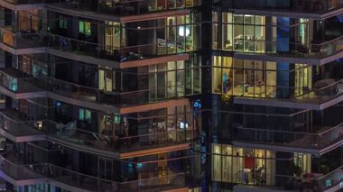 Çok katlı binaların pencerelerinde düz gece panoramasında çok renkli ışık var..