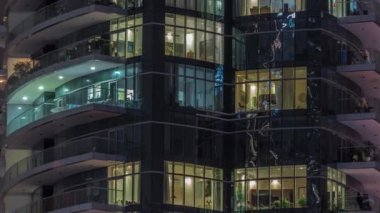Çok katlı binaların pencerelerinde düz gece panoramasında çok renkli ışık var..