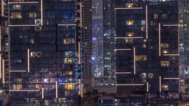 Çok katlı binaların pencerelerinde düz gece panoramasında çok renkli ışık var..