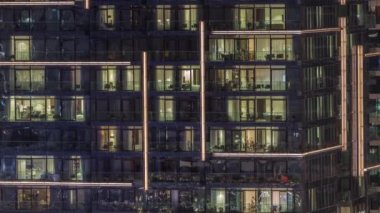 Çok katlı binaların pencerelerinde düz gece panoramasında çok renkli ışık var..