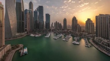 Dubai marinası üzerinde gün doğumu Limandaki en yüksek gökdelenler ve yatlar.