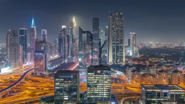 Panorama del distrito del Centro Financiero de Dubai con rascacielos altos iluminados por la noche timelapse. — Vídeos de Stock