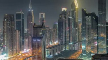 Dubai Finansal Merkezi 'nin gece saatlerinde aydınlatılan gökdelenleri..