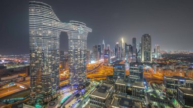Fütürist Dubai Şehir Merkezi ve finans bölgesi gökyüzü gece saatinde. Kavşakta trafik olan pek çok aydınlık kule ve gökdelen
