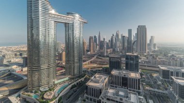 Fütürist Dubai Şehir Merkezi ve finans bölgesi ufuk çizgisi zaman çizelgesi. Caddelerde trafik olan birçok kule ve gökdelenler. Güneş cam yüzeyden yansıyor