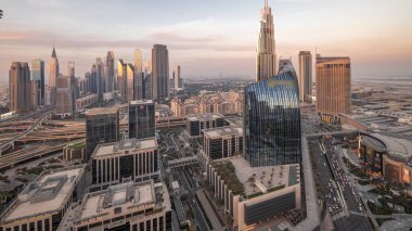 Fütürist Dubai Şehir Merkezi ve finans bölgesi silüeti panorama havadan geceye geçiş zamanı. Birçok aydınlık kule ve gökdelenler caddelerde trafik var.