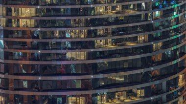 Gece vakti üst sınıf bir binanın pencerelerinin önünde oturuyorlardı. Metal ve camdan gökdelende parlayan ışıklar