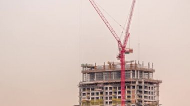 Tall buildings under construction and cranes timelapse