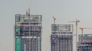 Tall buildings under construction and cranes night timelapse