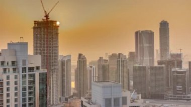 Aerial sunrise over big futuristic city timelapse. Business bay and Downtown