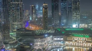 Dubai şehir merkezinde fıskiyelerin yanında ve modern fütüristik mimari gece saatleri.