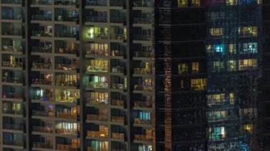 Gece vakti apartman pencereleri, aydınlatılmış evlerin ışıkları...