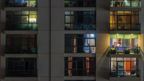 Vinduer i lejlighedskompleks om natten timelapse, lyset fra belyste værelser i huse – Stock-video