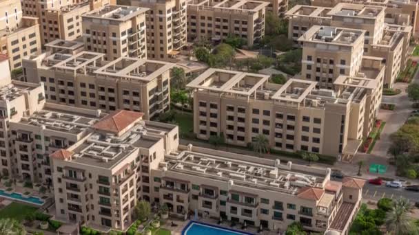 Nízké budovy ve čtvrti Greens s bazénem vzdušné timelapse. Dubaj panorama — Stock video