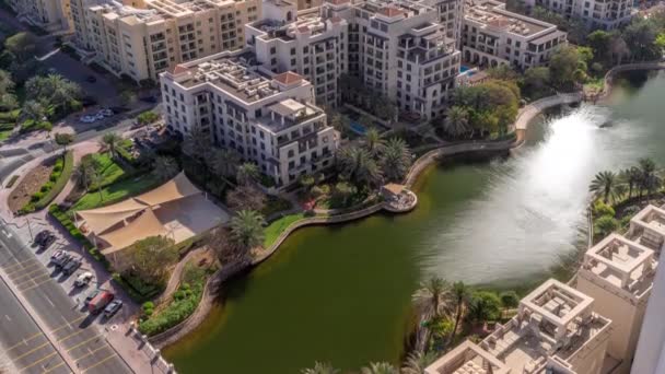 Rybník s fontánou a nízkoúrovňovými budovami ve vzdušném prostoru Zelené čtvrti. Dubaj panorama — Stock video
