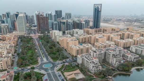 Rascacielos en el distrito de Barsha Heights y edificios de poca altura en el distrito de Greens durante el día y la noche. — Vídeos de Stock