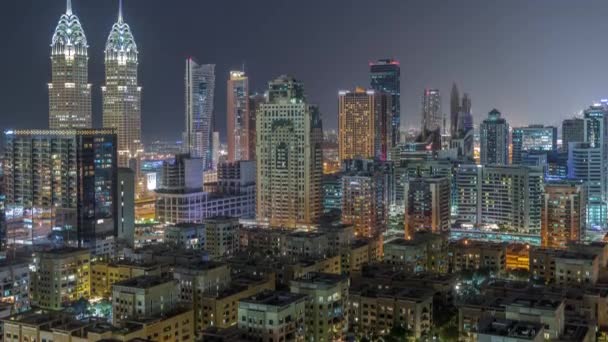 Rascacielos en el distrito de Barsha Heights y edificios de poca altura en el timelapse nocturno aéreo del distrito de Greens. — Vídeos de Stock