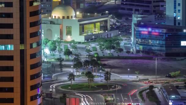 Mezquita y rascacielos en el distrito de Barsha Heights y el tráfico en una intersección de carretera circular noche aérea timelapse — Vídeos de Stock