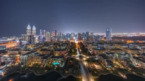 Panorama över skyskrapor i distriktet Barsha Heights och låga byggnader i gröna distriktet antenn natt timelapse. — Stockvideo