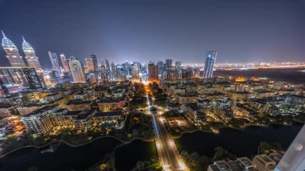Panorama de rascacielos en el distrito de Barsha Heights y edificios de poca altura en el timelapse nocturno aéreo del distrito de Greens. — Vídeos de Stock