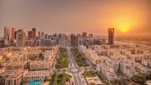 Salida del sol sobre rascacielos en el distrito de Barsha Heights y edificios de poca altura en el timelapse aéreo del distrito de Greens. — Vídeos de Stock