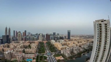 Barsha Heights bölgesinde gökdelenleri olan bir panorama ve Yeşiller Bölgesi hava sahasında alçak katlı binalar..