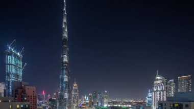 Dubai şehir merkezi panoramik şehir manzarası. Tüm gece boyunca havanın etrafında en yüksek gökdelenler var. Yukarıdan yeni kuleler inşa ediliyor ve ışıklar kapanıyor