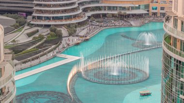 Dubai 'de havadan zaman ayarlı yürüme alanı olan çeşmeler. İnsanlar gün batımında alışveriş merkezinin yakınındaki şovu izliyor