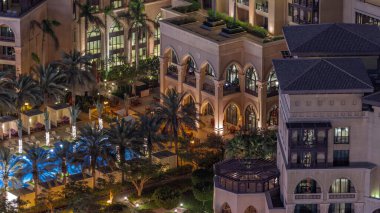 Yüzme havuzunun havuz manzarası. Eski Şehir Adası 'nda avuçlar gece vaktinden kalma. Dubai şehir merkezinde aydınlatılmış geleneksel binalar