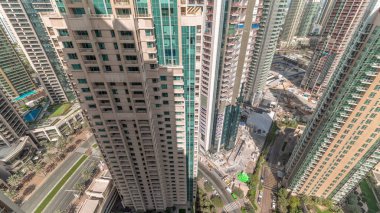 Şehir merkezindeki modern Dubai mimarisi ile havadan çekilmiş zaman çizelgesi. Yüksek gökdelenlere ve gölgeleri hızlı hareket eden kulelere bakın. Yeni inşaat alanı.
